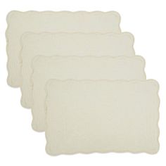 four white placemats with scalloped edges in various sizes and colors on a white background