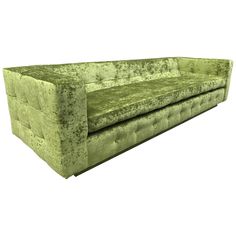 a green velvet couch with buttons on the back and arms, sitting against a white background