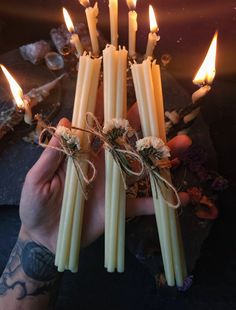 a person holding several candles in their hands