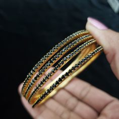 "* Handcrafted Gold Plated 4 Bangle Set. Sold as a set. * Bangles with high quality black stones. * High Quality 22K Gold Plated. Bangles Sizes : 2.4 inches= ( 2.25\" diameter of the inner circle) ; 2.6 inches = ( 2.40\" diameter of the inner circle); 2.8inches = (2.54\" diameter of the inner circle) The gorgeous gold-plated bangles set best exemplifies the careful craftsmanship done on it -- specially picked for you by Nemali Jewelry. It has a special tone of elegance attached to it. The intric Traditional Black Bracelets For Party, Traditional Black Party Bracelets, Traditional Black Bracelets For Weddings, Traditional Black Bracelet For Wedding, Traditional Black Wedding Bracelets, Black Bangle Bracelets For Festive Occasions, Festive Black Bangle Bracelets, Festive Black Bangle Bracelet, Traditional Black Bangle Gift