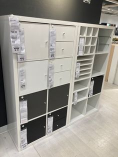 several mailboxs are stacked on top of each other in a storage room with black and white drawers