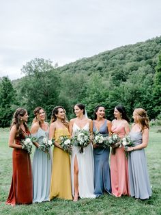 a group of women standing next to each other on top of a lush green field