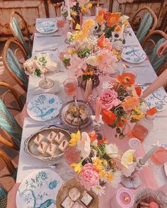 a long table with plates and flowers on it