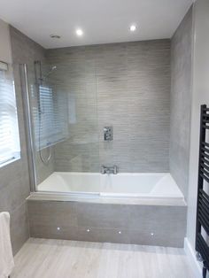 a bathroom with a bathtub, towel rack and shower head in it's corner