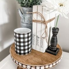 two coffee mugs are sitting on a tray with books and a flower in it