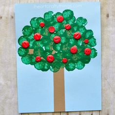 an apple tree made out of paper with red buttons on the top and green leaves