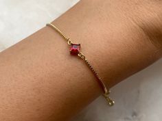 Dainty ruby red rhombus gold plated bracelet with beautiful dangly rhinestone ends Charm size approximately 11 mm x 7 mm Gold plated brass bracelet Every order comes in our luxury matt frosted recyclable logo pouch, which are also available to purchase separately for any extra pieces you may want to store with style. Gift wrap sets (box & faux leather pouch)  are available at checkout and available to buy separately. Red Dainty Jewelry At Affordable Prices, Elegant Cheap Red Bracelets, Affordable Personalized Red Bracelet, Ruby Bracelet, Brass Bracelet, Pretty Bracelets, Gold Plated Bracelets, July Birthstone, Gorgeous Gift