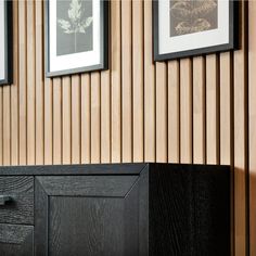 a black cabinet sitting in front of a wall with pictures on it's side