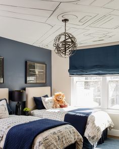 two twin beds in a bedroom with blue walls and white trimmings on the ceiling