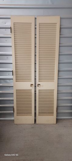 two closed doors in front of a garage door with shutters on the sides and bottom