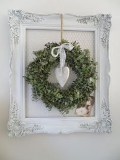 a white frame with a wreath hanging on it