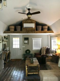 a living room filled with furniture and a ceiling fan