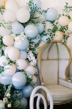 a chair and balloon arch with flowers on it