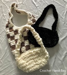 two crocheted purses sitting on top of a white tablecloth covered surface