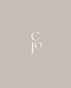 the letters c and j are made out of white paper on a light gray background