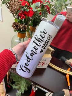 a woman is holding a water bottle with the word grandma written on it in black ink