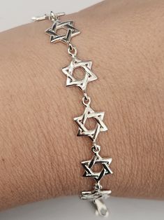 This lovely bracelet is made of 925 Sterling Silver and features 10 Star of David links. The stars are beautifully made and rounded. The chain has a secure lobster clasp. It’s one of our most popular bracelets for Bat Mitzvah girls and adult women alike. The bracelet measures 7" long by 3/8” wide. Matching earrings available! Elegant Sterling Silver Star Bracelet, Elegant Sterling Silver Bracelets With Star Charm, Adjustable Sterling Silver Star Bracelet, Elegant Silver Star Chain Bracelet, Elegant Silver Star-shaped Chain Bracelet, Silver Star-shaped Bracelet With Adjustable Chain, Nickel-free Silver Star Bracelet, Sterling Silver Star Bracelet As Gift, Red Leather Bracelet