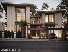 a car is parked in front of a two story house at night with palm trees