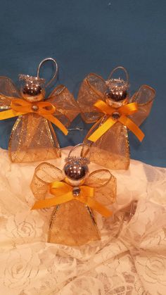 three glass bell ornaments with yellow bows