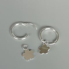 A PAIR of sterling silver hoops. Comes with a detachable cut out flower charm. The charm is multipurpose and can be used with a neck or bracelet chain too. Dimension: Hoop- 12 x 1.5 mm Charm: 7 x 11 mm Drop length- 21 mm These earrings are made of 925 hypoallergenic sterling silver and plastic. Please note this price is for ONE PAIR. All my pieces are sent in a gift box. I can include a personal message from you if needed You are welcome to contact me at... bhavnakwintra1956@gmail.com For more b Silver Dainty Hoop Earrings With Dangling Charms, Silver Huggie Earrings With Charms, Silver Dangle Hoop Earrings With Charms, Sterling Silver Huggie Earrings With Dangling Charms, Sterling Silver Huggie Earrings With Charms, Silver Earrings With Flower Charm For Everyday, Everyday Silver Earrings With Flower Charm, Round Hoop Earrings With Flower Charm As Gift, Silver Dangle Huggie Earrings With Charms