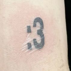 the number three is covered in plastic on top of a person's arm,