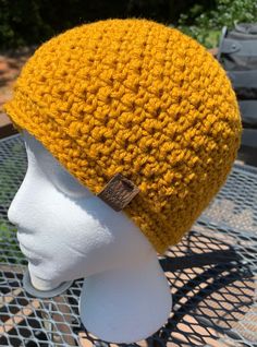 a yellow knitted hat sitting on top of a white mannequin's head