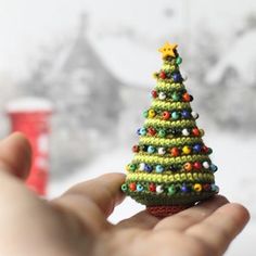 a hand holding a small crocheted christmas tree