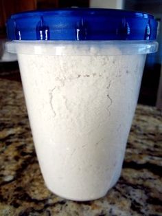 a blue lid on a plastic cup filled with white powder sitting on top of a counter