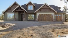 a large brown house with two garages on the front and one car door open