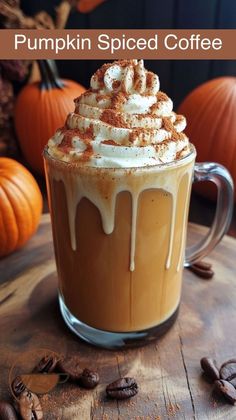 a pumpkin spiced coffee with whipped cream and cinnamon on top is sitting on a wooden table