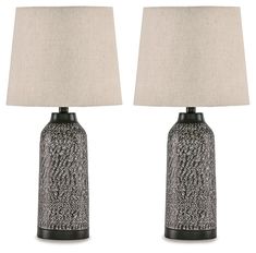 a pair of black and white ceramic lamps with linen shades on each lamp shade,