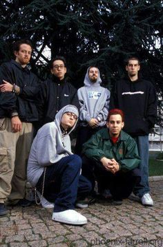 a group of young men standing next to each other on a brick floored walkway