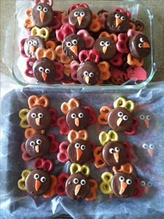 there are many decorated turkey cookies in the glass dish on the table and next to each other