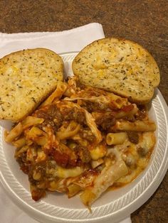 a white plate topped with pasta and bread