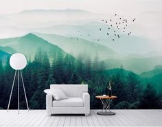 a living room with a white couch sitting on top of a hard wood floor next to a wall mural