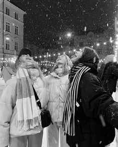 two women standing in the snow with their eyes closed