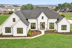 a large white house sitting on top of a lush green field