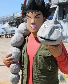 a man holding two stuffed animals in front of him on the deck of a ship