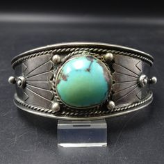 OLD PAWN BRACELET c1940s DESCRIPTION:  A breathtaking specimen of natural turquoise, beginning to green with age, set in heavy gauge vintage sterling silver. Applied raindrops, some with stampwork, and fine twisted silver enhance the face of the cuff. This extraordinary bracelet will be a cherished addition to your collection of fine vintage Southwestern and Native American jewelry. MEASUREMENTS: Interior of the cuff measures 5 1/2" with an additional 1" slightly adjustable gap. Total circumfere Vintage Turquoise Sterling Silver Bracelets, Antique Turquoise Jewelry With Patina, Vintage Turquoise Ring With Polished Finish, Vintage Turquoise Bracelet, Vintage Turquoise Round Jewelry, Collectible Vintage Turquoise Ring With Polished Finish, Vintage Jewelry With Patina, Vintage Round Jewelry With Patina, Classic Hallmarked Turquoise Jewelry