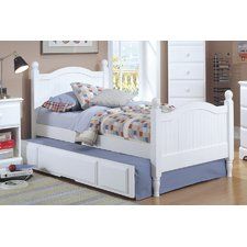 a white bed with drawers underneath it and a night stand in front of the bed