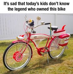 a red and white bike parked in the grass