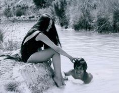 two people sitting in the water next to each other