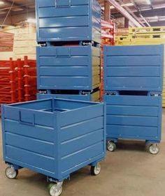 three blue boxes on wheels in a warehouse