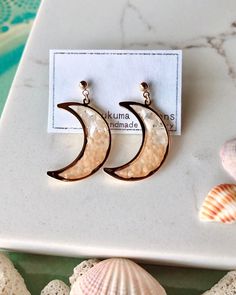 Material: *16k gold filled over brass earring studs *Crescent Moon Brass Frame *mother of pearls  *Coral Coral and mother of pearls in Crescent Moon earrings look so cute at beach in summer!  Length: approx. 25mm 🤍All item(s) comes in a gift box. 🤍Items are shipped via USPS.  🤍Follow our Instagram so you won't miss out new items and update!  Search "kurukuma_design"  Or  https://www.instagram.com/kurukuma_design/ 🤍Care Guide: - This product is water resistant. - Avoid using harsh cleaning ch Gold Crescent Earrings With Moon Phase Detail, 14k Gold Filled Crescent Earrings As Gift, Gold Half Moon Pierced Earrings, Gold Half Moon Earrings With Moon Charm, Gold Moon Shaped Earrings For Gift, Gold Moon-shaped Earrings For Gift, Gold Earrings With Moon Charm As Gift, Crescent-shaped Gold Plated Earrings As Gift, Handmade Gold Half Moon Earrings