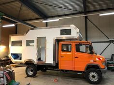 an orange and white truck parked in a garage