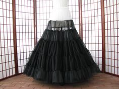 "The pictured petticoat was a custom order for a bride. The reason for the white top is so that the dark color does not cast a shadow underneath the fitted torso of a white or ivory gown. The design of this petticoat is so that the most fullness is at the hem of the skirt with little to no added fullness in the hip area. This sale is for a custom version of the pictured black and white single layer petticoat made out of soft nylon chiffon. The waist will be .75\" (2cm) wide elastic that will be Black Full Skirt Petticoat For Wedding, Elegant Black Tulle Petticoat, Fitted Petticoat For Costume, Black Full Skirt Crinoline Petticoat, Black Crinoline Full Skirt Petticoat, Elegant Black Full Skirt Petticoat, Fitted Crinoline Petticoat For Party, Black Crinoline Petticoat For Wedding, Fitted Full Skirt Petticoat With Attached Cancan