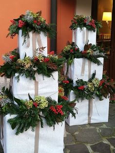 three white bags with christmas wreaths on them are sitting in front of a building