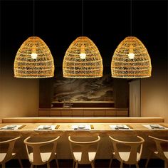 three lights hanging over a long table in a restaurant