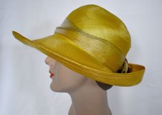 A vintage 1980s saffron yellow woven straw cloche style sun hat with an antique gold wide ribbon band and a pale copper silk rose with metallic gold edges.  The hat was made in USA by Plaza  suite by Betmar.  The hat has a 1/2 inch rip at the back of the crown and a 1 inch green mark on the inner band.  The brim is 4 inches wide at the front, the crown is 4 inches tall, 7 inches front to back and 6 inches side to side measured across the top, 24 inches around the inner gros grain band.  7 oz., boxed Please also follow me on Instagram at ChrisMartinDesigns Gold Fedora Straw Hat For Kentucky Derby, Gold Brimmed Straw Hat, Gold Wide-brim Straw Hat For Kentucky Derby, Gold Wide Brim Straw Hat For Kentucky Derby, Gold Brimmed Straw Hat For Kentucky Derby, Gold Fedora For Kentucky Derby, Adjustable Gold Straw Hat For Kentucky Derby, Fitted Gold Summer Hat, Gold Curved Brim Hat For Kentucky Derby