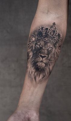 a lion with a crown tattoo on his arm